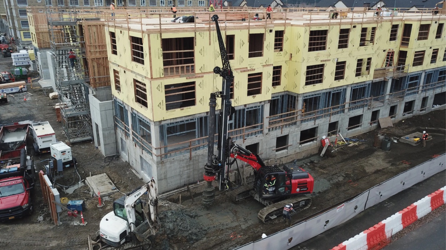 A wood-framed building under construction with equipment on the site
